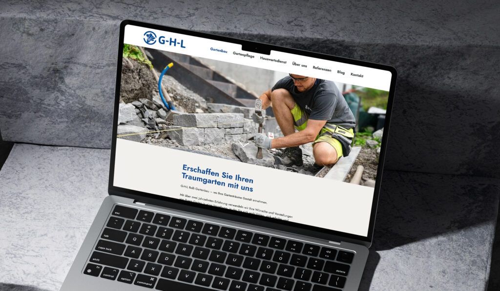 Ein Laptop, auf dem die von Clicdesign AG gestaltete Website eines Landschaftsbauunternehmens angezeigt wird, zeigt Fachkenntnisse in Werbung, Printdesign und Webdesign. Auf dem Bildschirm ist ein Mann in Arbeitskleidung zu sehen, der einen Steinweg baut, was die professionellen Landschaftsbaudienste des Unternehmens hervorhebt. Die Navigationsleiste der Website ist oben sichtbar und spiegelt die benutzerfreundlichen und optisch ansprechenden Webdesigntechniken von Clicdesign AG wider, die auf effektive Werbestrategien zugeschnitten sind.